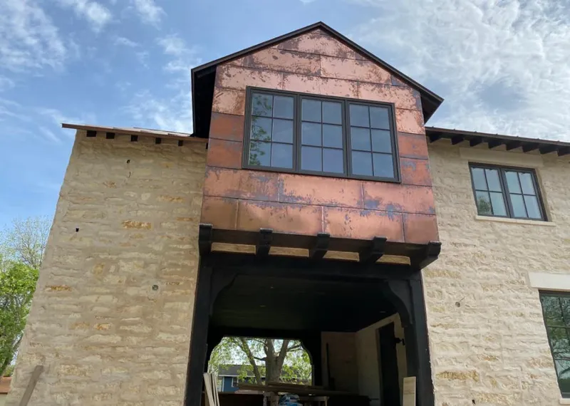Copper metal panel facade on a stone building for Roof Repair in Taos