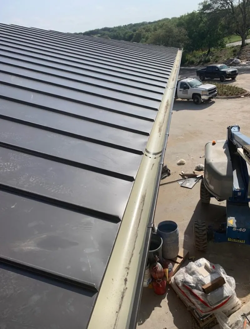 Standing seam panel and gutter detail on a metal roofing jobsite in Taos